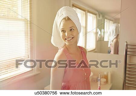 Young woman standing in bathroom View Large Photo Image Stock Photograph - Young woman standing in bathroom. Fotosearch