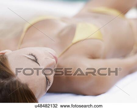 Young woman sunbathing at hotel poolside View Large Photo Image Stock Image - Young woman sunbathing at hotel poolside. Fotosearch