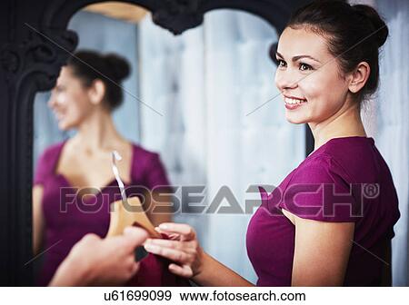 Stock Photo - Young woman trying on dress. Fotosearch