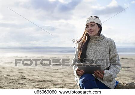 Young woman using digital tablet, Brean Sands, Somerset, England View Large Photo Image Stock Image - Young woman using digital tablet, Brean Sands, Somerset, England. Fotosearch