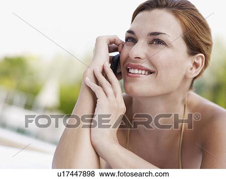 Young woman using mobile phone whilst sunbathing View Large Photo Image Stock Photo - Young woman using mobile phone whilst sunbathing. Fotosearch