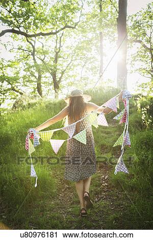 Young woman walking with bunting in forest View Large Photo Image Stock Image - Young woman walking with bunting in forest. Fotosearch