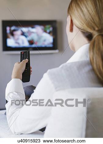 Young woman watching television in hotel room View Large Photo Image Stock Image - Young woman watching television in hotel room. Fotosearch