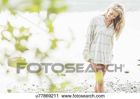 Stock Image - Young woman wearing shirt. Fotosearch