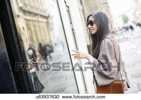 Young woman window shopping View Large Photo Image Stock Image - Young woman window shopping. Fotosearch