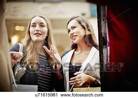 Stock Image - Young women window shopping. Fotosearch