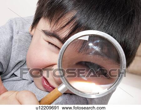 Boy looking through magnifying glass View Large Photo Image Stock Image - Boy looking through magnifying glass. Fotosearch
