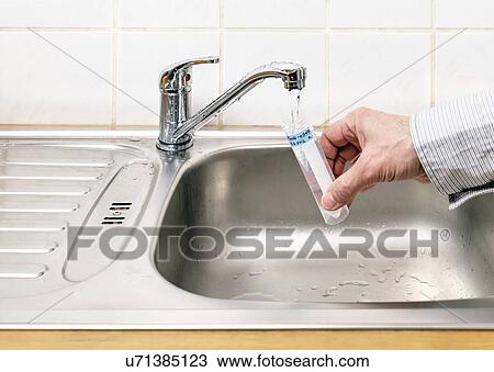 Stock Image - Collecting tap water sample. Fotosearch