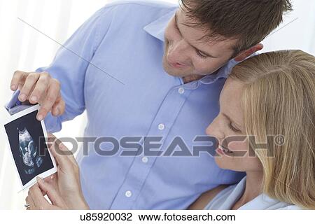 Couple looking at baby scan View Large Photo Image Stock Image - Couple looking at baby scan. Fotosearch