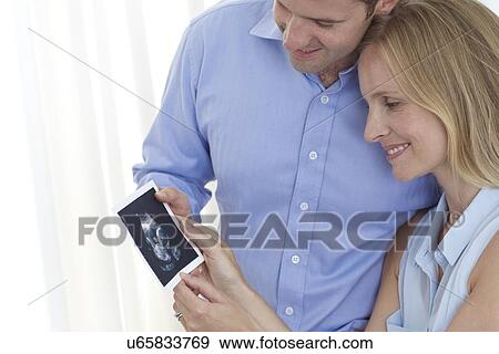 Couple looking at baby scan View Large Photo Image Stock Photo - Couple looking at baby scan. Fotosearch