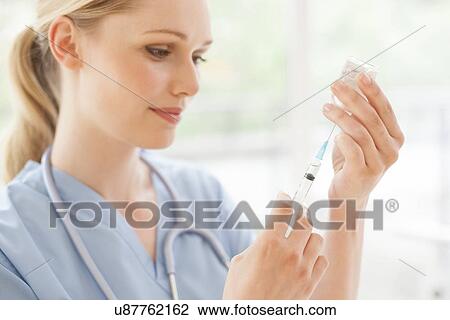 Stock Image - Doctor preparing injection. Fotosearch
