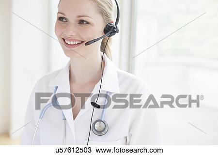 Doctor using a headset View Large Photo Image Stock Image - Doctor using a headset. Fotosearch
