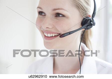 Doctor using a headset View Large Photo Image Stock Image - Doctor using a headset. Fotosearch
