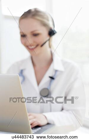 Doctor using a laptop computer View Large Photo Image Stock Image - Doctor using a laptop computer. Fotosearch
