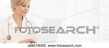 Doctor using a laptop computer View Large Photo Image Stock Image - Doctor using a laptop computer. Fotosearch
