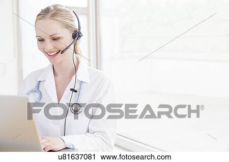 Stock Image - Doctor using a laptop computer. Fotosearch
