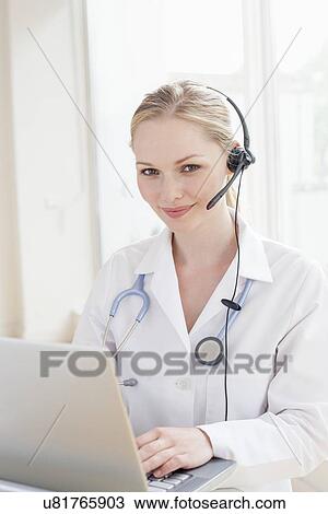 Stock Image - Doctor using a laptop computer. Fotosearch