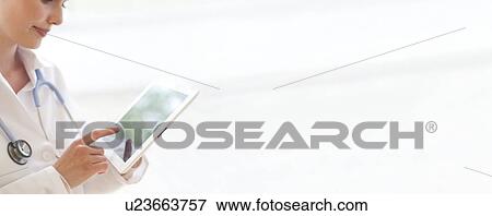 Stock Photo - Doctor using a tablet computer. Fotosearch
