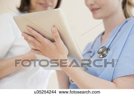 Doctors using a tablet computer View Large Photo Image Picture - Doctors using a tablet computer. Fotosearch