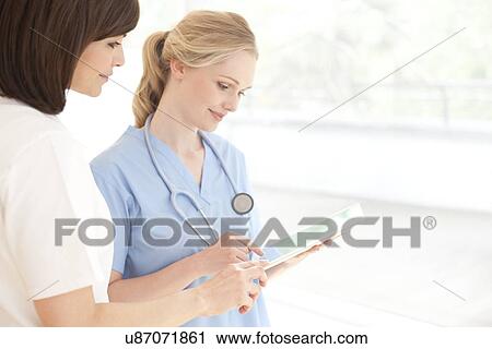 Stock Image - Doctors using a tablet computer. Fotosearch