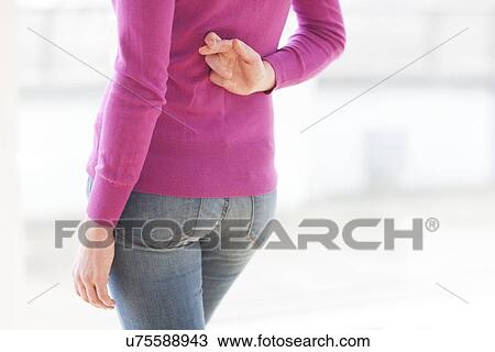 Fingers crossed behind woman's back View Large Photo Image Stock Image - Fingers crossed behind woman's back. Fotosearch