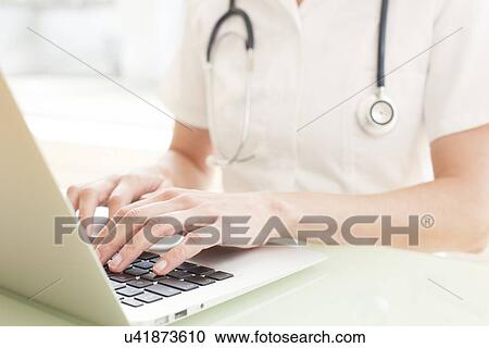 Nurse using a laptop computer View Large Photo Image Stock Image - Nurse using a laptop computer. Fotosearch