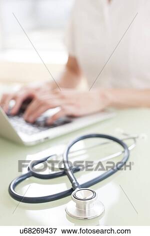 Stock Photo - Nurse using a laptop computer. Fotosearch