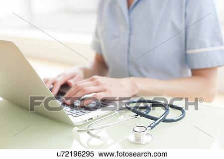 Nurse using a laptop computer View Large Photo Image Stock Photography - Nurse using a laptop computer. Fotosearch