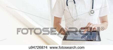 Nurse using a tablet computer View Large Photo Image Picture - Nurse using a tablet computer. Fotosearch