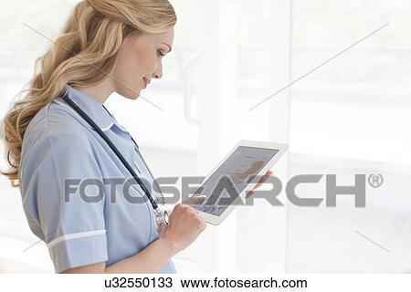 Nurse using a tablet computer View Large Photo Image Stock Image - Nurse using a tablet computer. Fotosearch