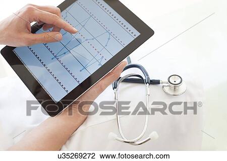 Stock Image - Nurse using a tablet computer. Fotosearch