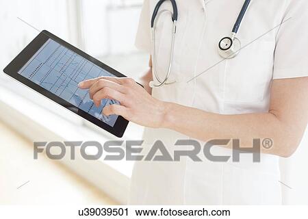 Nurse using a tablet computer View Large Photo Image Stock Image - Nurse using a tablet computer. Fotosearch