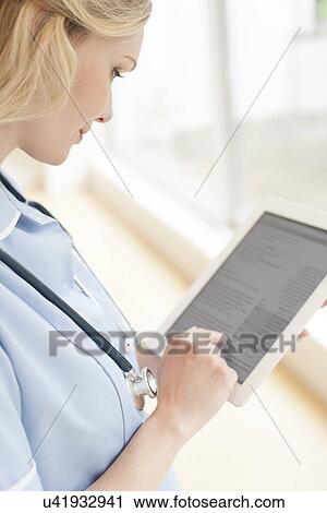 Stock Image - Nurse using a tablet computer. Fotosearch