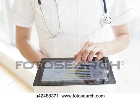 Nurse using a tablet computer View Large Photo Image Stock Image - Nurse using a tablet computer. Fotosearch