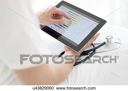 Nurse using a tablet computer View Large Photo Image Stock Image - Nurse using a tablet computer. Fotosearch