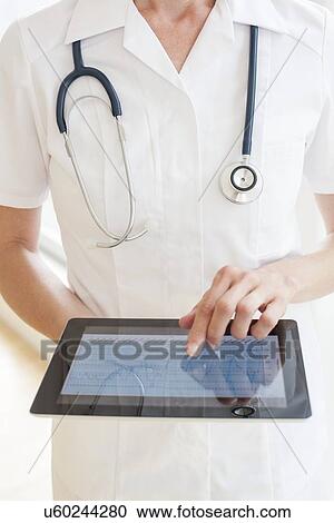 Stock Image - Nurse using a tablet computer. Fotosearch