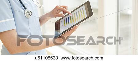 Stock Image - Nurse using a tablet computer. Fotosearch