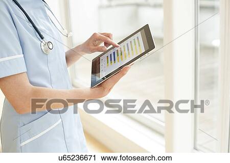 Stock Image - Nurse using a tablet computer. Fotosearch