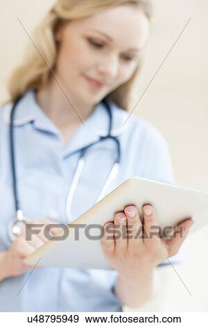Nurse using a tablet computer View Large Photo Image Stock Photo - Nurse using a tablet computer. Fotosearch