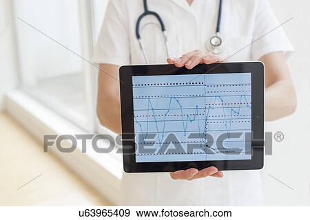 Nurse using a tablet computer View Large Photo Image Stock Photo - Nurse using a tablet computer. Fotosearch