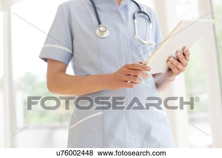 Stock Photo - Nurse using a tablet computer. Fotosearch