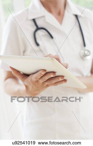 Nurse using a tablet computer View Large Photo Image Stock Photo - Nurse using a tablet computer. Fotosearch
