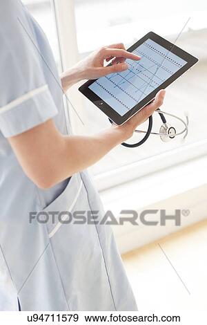 Stock Photo - Nurse using a tablet computer. Fotosearch