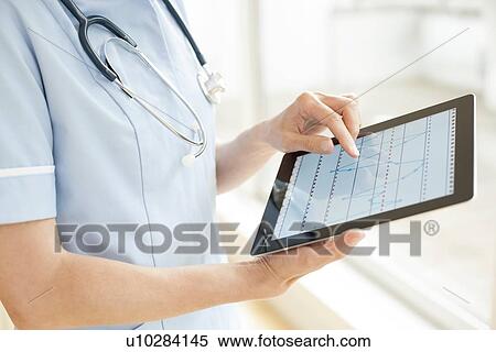 Stock Photography - Nurse using a tablet computer. Fotosearch