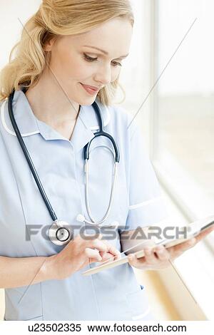 Stock Photography - Nurse using a tablet computer. Fotosearch