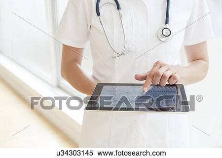 Nurse using a tablet computer View Large Photo Image Stock Photography - Nurse using a tablet computer. Fotosearch