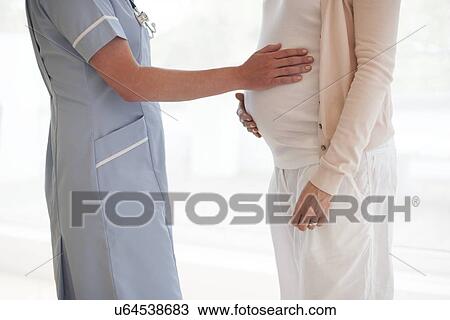 Stock Image - Pregnant woman and nurse. Fotosearch