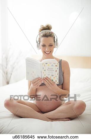 Stock Photography - Pregnant woman choosing baby names. Fotosearch
