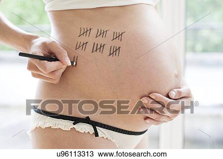 Stock Image - Pregnant woman counting down to due date. Fotosearch