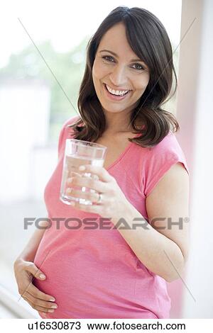 Pregnant woman drinking water View Large Photo Image Stock Image - Pregnant woman drinking water. Fotosearch